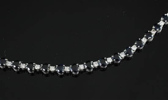 A white gold, sapphire and diamond line bracelet, 6.75in.